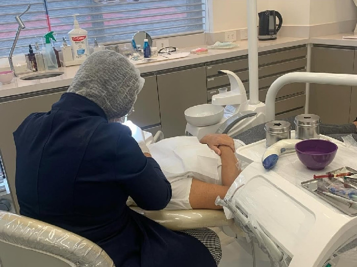 Profissional da Magnus Odontologia atendendo paciente em consultório moderno, no SRTVN, em Brasília